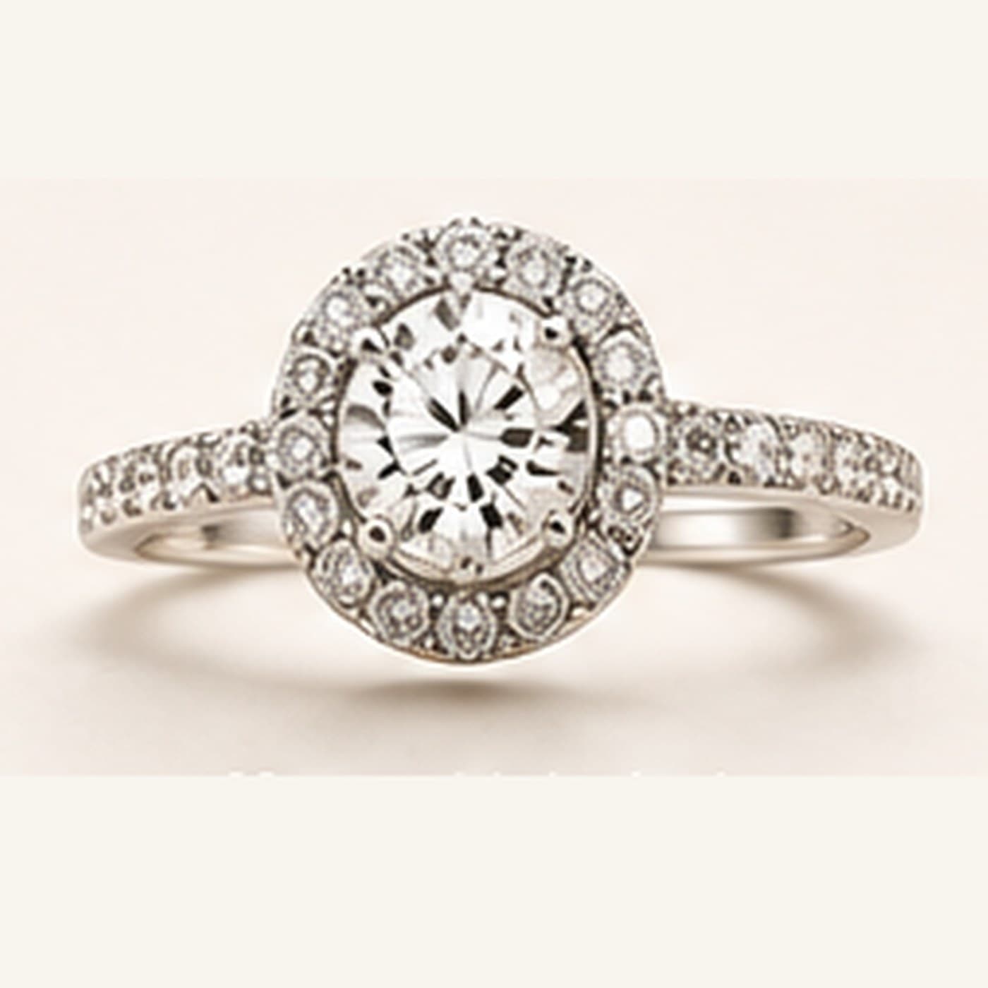 White metal oval halo ring with a round centre diamond
